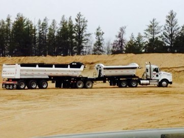 Barnhart Transport triple trailer parked in a sandy quarry pit
